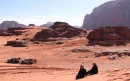 Ladies at base of Dune * 2 of the women from our tour group sitting half-way up the sand dune at Wadi Rum.  Jim is sitting in the truck below, sending an email. * 576 x 362 * (80KB)